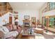 Inviting living room featuring a stone fireplace, vaulted ceilings, and natural light at 533 Tenderfoot Dr, Larkspur, CO 80118