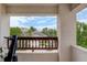 Balcony view framed by concrete walls, offering a glimpse of neighborhood trees and a cloudy blue sky at 5757 W Alamo Dr, Littleton, CO 80123