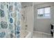 Clean bathroom with a shower-tub and a seashell-themed shower curtain, providing a fresh and vibrant feel at 5757 W Alamo Dr, Littleton, CO 80123