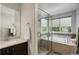Bathroom featuring a shower, bathtub, and tile accents, with a bright window providing natural light at 5757 W Alamo Dr, Littleton, CO 80123