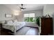 Serene bedroom with a ceiling fan, large window, and a cozy bed with a decorative patterned quilt at 5757 W Alamo Dr, Littleton, CO 80123