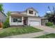 Inviting two-story home featuring a red front door, a balcony, and a well-maintained lawn at 5757 W Alamo Dr, Littleton, CO 80123