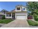 Inviting two-story home featuring a red front door, a balcony, and a well-maintained lawn at 5757 W Alamo Dr, Littleton, CO 80123