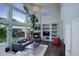 Spacious living room featuring large windows, a cozy fireplace, and built-in shelving for added convenience at 5757 W Alamo Dr, Littleton, CO 80123
