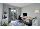 Bright office space with a desk, a sliding glass door to a balcony, and a blue patterned rug at 5757 W Alamo Dr, Littleton, CO 80123