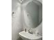 Elegant powder room with a pedestal sink, a round mirror, and modern fixtures at 5757 W Alamo Dr, Littleton, CO 80123