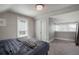 Bright bedroom with gray carpet, a large window, a modern light fixture, and an attic space at 2253 S Fox St, Denver, CO 80223