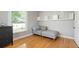 Well-lit bedroom features hardwood floors, a gray chaise lounge, and a black dresser under the window at 2253 S Fox St, Denver, CO 80223