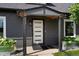 Inviting front entrance with modern white door, gray siding, and stylish planters at 2253 S Fox St, Denver, CO 80223