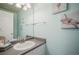 Coastal bathroom featuring a vanity with a white sink and nautical-themed artwork, creating a serene atmosphere at 114 Vale St, Palmer Lake, CO 80133