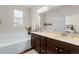 A bright bathroom with a double vanity, soaking tub, and stained glass window at 132 Ambrose St, Erie, CO 80516