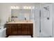 Bright bathroom featuring a double vanity, glass shower, and soaking tub at 132 Ambrose St, Erie, CO 80516