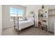 Bright bedroom featuring a metal bed frame, large window, white walls and a bookcase filled with books at 132 Ambrose St, Erie, CO 80516
