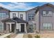 Charming townhome featuring a covered entryway, stone accents, and manicured landscaping at 132 Ambrose St, Erie, CO 80516