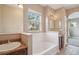 Bright bathroom with soaking tub under window, vanity with sink at 12921 Grant Cir # B, Thornton, CO 80241