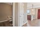 Hallway view of a half bath with a toilet, pedestal sink, and wood floors at 12921 Grant Cir # B, Thornton, CO 80241
