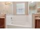 Bathroom featuring soaking tub with tiled backsplash and dual sinks at 12921 Grant Cir # B, Thornton, CO 80241