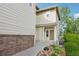 Front entrance with a covered porch, siding, brick accents, and landscaping at 12921 Grant Cir # B, Thornton, CO 80241