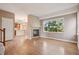 Open-concept living room with wood floors, fireplace, and large window at 12921 Grant Cir # B, Thornton, CO 80241