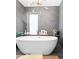 Modern bathroom featuring a freestanding tub, stylish light fixture, and sleek gray tiling at 2838 Tennyson St, Denver, CO 80212