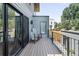 Exterior view of a deck with a wood floor, metal railings, a pair of chairs, and sliding glass door at 2838 Tennyson St, Denver, CO 80212