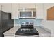 Kitchen featuring stainless steel microwave and range hood and glass tile backsplash at 2727 Folsom St # 303, Boulder, CO 80304