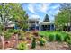 Landscaped backyard featuring garden beds, a two-story home, and a covered patio with a grill at 13496 Alcott Way, Broomfield, CO 80020