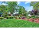 Manicured backyard featuring green lawn, garden beds, mature trees, and a fenced perimeter for privacy at 13496 Alcott Way, Broomfield, CO 80020