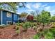 Landscaped backyard featuring garden beds, a two-story home, and a covered patio with a grill at 13496 Alcott Way, Broomfield, CO 80020