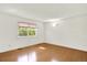 Bright bedroom featuring hardwood floors, fresh paint, and large window with backyard views at 13496 Alcott Way, Broomfield, CO 80020