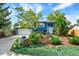 Charming two-story blue home with lush landscaping, mature trees, and an attached two-car garage at 13496 Alcott Way, Broomfield, CO 80020