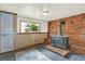 Cozy living room with a wood-burning stove and rustic brick accent wall at 13496 Alcott Way, Broomfield, CO 80020