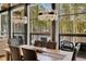 Elegant dining area with a long wooden table, leather chairs, and picturesque forest views at 55 Blue Flag Dr, Breckenridge, CO 80424