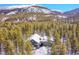 Aerial view of a modern home surrounded by a dense forest in a snowy mountain landscape at 55 Blue Flag Dr, Breckenridge, CO 80424