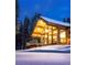Picturesque view of modern home with snowy landscape at nighttime at 55 Blue Flag Dr, Breckenridge, CO 80424