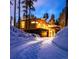 Snowy driveway leading to a modern home with a two-car garage and inviting exterior lighting at 55 Blue Flag Dr, Breckenridge, CO 80424