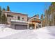 Contemporary exterior with a two-car garage and a balcony against a backdrop of tall trees at 55 Blue Flag Dr, Breckenridge, CO 80424