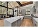 Open-concept kitchen with island seating, modern appliances, and large windows showcasing forest views at 55 Blue Flag Dr, Breckenridge, CO 80424