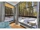 Inviting nook features floor-to-ceiling windows showcasing a picturesque winter wonderland and a private hot tub at 55 Blue Flag Dr, Breckenridge, CO 80424