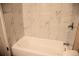 This bathroom features a white tub with marble tile walls at 875 S Quebec St # 25, Denver, CO 80247