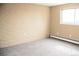 Bedroom featuring brick accent wall, neutral carpet, and a window for natural light at 875 S Quebec St # 25, Denver, CO 80247