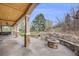 Inviting covered back patio with stone fire pit and landscaped backyard, perfect for outdoor gatherings at 6398 Lost Canyon Ranch Rd, Castle Rock, CO 80104