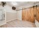 View of bedroom with sliding barn door and wood laminate flooring at 6398 Lost Canyon Ranch Rd, Castle Rock, CO 80104