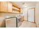 Practical laundry room is equipped with cabinetry, sink and modern appliances at 6398 Lost Canyon Ranch Rd, Castle Rock, CO 80104