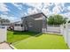 Backyard featuring an artificial putting green, lush lawn, and crisp white fencing, perfect for outdoor recreation and leisure at 1100 S Garfield St, Denver, CO 80210