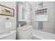 Well-lit bathroom with a glass block window, decorative tile accents, and modern fixtures over a standard tub at 1100 S Garfield St, Denver, CO 80210