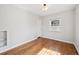 Bright bedroom featuring hardwood floors, a built-in bookshelf, and a window offering natural light and neighborhood views at 1100 S Garfield St, Denver, CO 80210