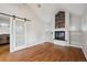 Living room features a fireplace, hardwood floors, vaulted ceilings, and a sliding barn door to the kitchen at 1100 S Garfield St, Denver, CO 80210