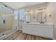 Luxurious bathroom with a dual sink vanity, a glass-enclosed shower, and modern fixtures at 4880 River Landing Ave, Firestone, CO 80504