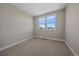 Comfortable bedroom featuring two windows with views and carpet flooring at 4880 River Landing Ave, Firestone, CO 80504
